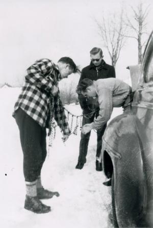 Science professor Buck Turner helps John Kohler ’49 and Ted Havness ’51 apply tire chains for a winter expedition on Vermont’s new infrastructure.