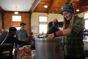 Sophomore Gini Graydon ladles up hot cider on Apple Days. Photo by Clair Maleney 