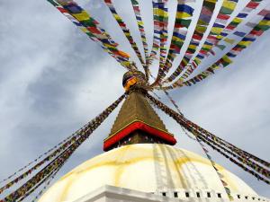 Prayer flags flutter on Boudhanath, the largest stupa in Nepal and one of several sacred sites destroyed by earthquakes last April. Photo by Jonah Nonomaque ’17