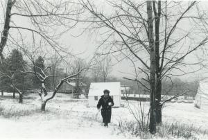A student walking up the hill toward the library weathers a winter storm in the 1980s. Photo by Robert George