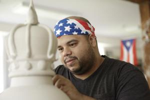 Roberto Lugo works on one of his large, ceramic vessels, which often feature images from popular culture. Photo by John Polak