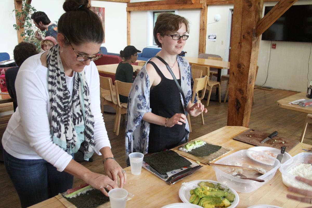 Kate Trzaskos, director of experiential learning and career development, and Bobbi Crocker '19 try their hands at rolling sushi during an international programs event.