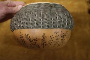 A basket crafted from gourd on the bottom and reed on the top symbolizes a meadow. “The design on the bottom represents the millions of seeds that float through the air,” Judy says.