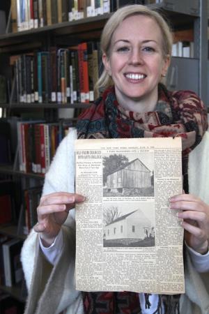 Library director Beth Ruane holds an original copy of a 1949 New York Times article titled “Old Farm Changed into Arts College,” one of many treasures found in the library archives.