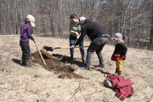 Writing and literature professor Bronwen Tate enlists her family to help dig holes for edible woody perennials at the farm. 