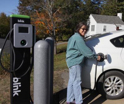 Biology professor Jenny Ramstetter charges up at the new EV charging station on campus. 