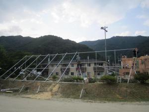 Workers build the first of three frames to hold arrays of photovoltaic panels, part of a solar electrification project in the hard-hit town of Kamaishi. Photo by Drew Tanabe