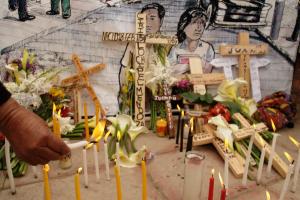 Survivors light candles and place crosses bearing the names of loved ones during a celebration of National Day for the Dignification of the Victims of the Armed Conflict, in Nebaj. Photo by Graham Charles Hunt  