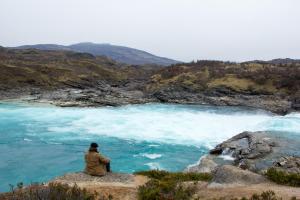 Matt takes time to ponder the impacts of eco-colonialism on the banks of a raging glacial river. Photo by Kelsey Hamm