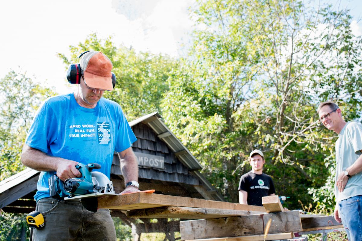 Chemistry professor Todd Smith designs and builds improvements to the compost system at the community farm during Work Day, with assistance by freshman Cedar Van Tassel and Asian studies professor Seth Harter. Photo by Kelly Fletcher