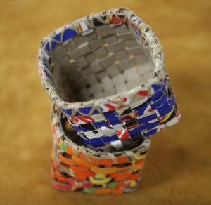 Two little baskets made from recycled materials—cereal boxes—are used by Judy to demonstrate basket-making techniques to children.