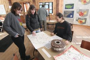 Eliza Rudegeair ’14, Kelley Hickey ’16, and history professor Adam Franklin-Lyons look over student maps, the product of a Cartography class that will become part of the Data Humanist Certificate Program. 