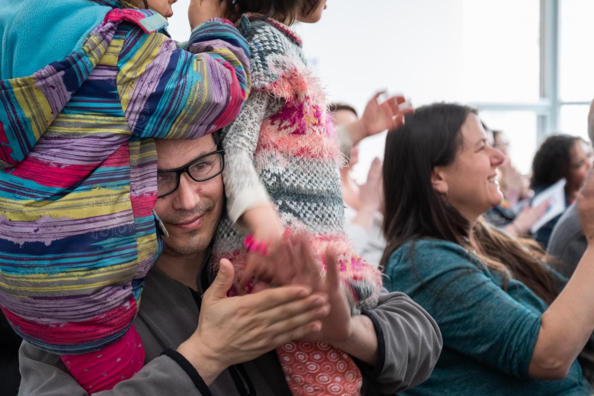 Philosophy professor William Edelglass claps for a Beautiful Minds Challenge presentation in April, while wearing his daughters Jasmine and Sarah. Photo by Kelly Fletcher